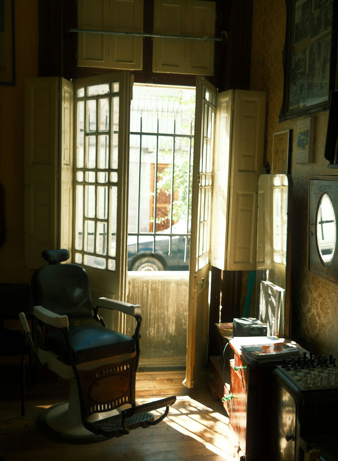The shop door propped open onto the street, sunlight across the floor